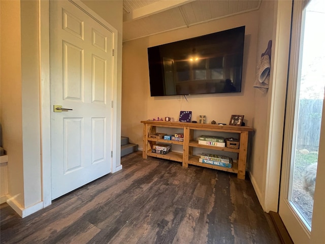 interior space with dark wood-type flooring and beamed ceiling