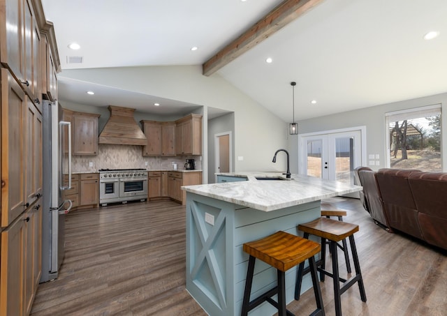 kitchen with appliances with stainless steel finishes, pendant lighting, sink, custom range hood, and french doors