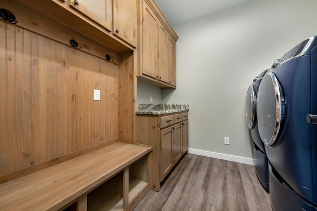 washroom with dark wood-type flooring, cabinets, and separate washer and dryer