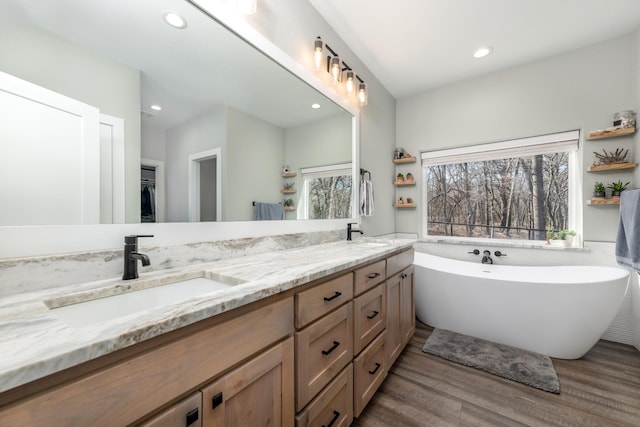 bathroom featuring vanity, hardwood / wood-style flooring, and a bathing tub