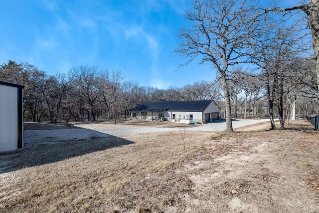 view of property exterior featuring a garage, a porch, and a lawn