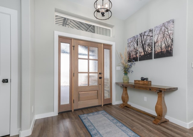 foyer with dark hardwood / wood-style flooring and a chandelier