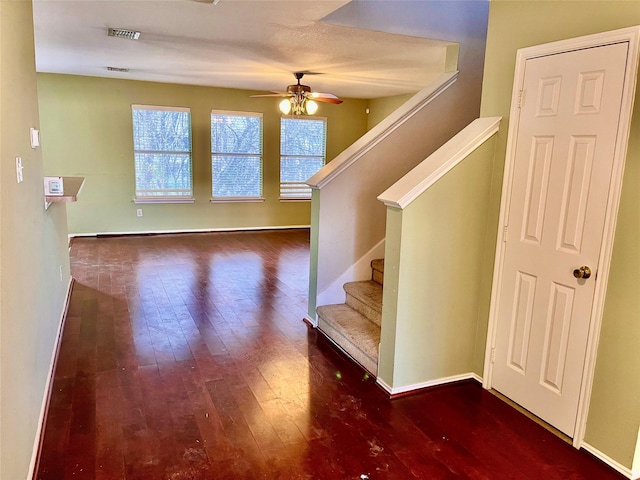 staircase featuring ceiling fan and hardwood / wood-style floors