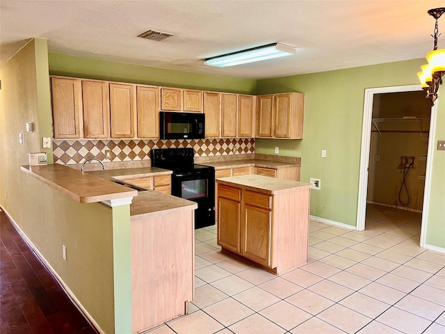 kitchen with tasteful backsplash, black appliances, kitchen peninsula, hanging light fixtures, and light brown cabinetry