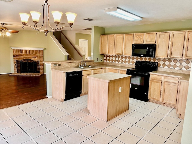 kitchen with a kitchen island, black appliances, kitchen peninsula, sink, and hanging light fixtures