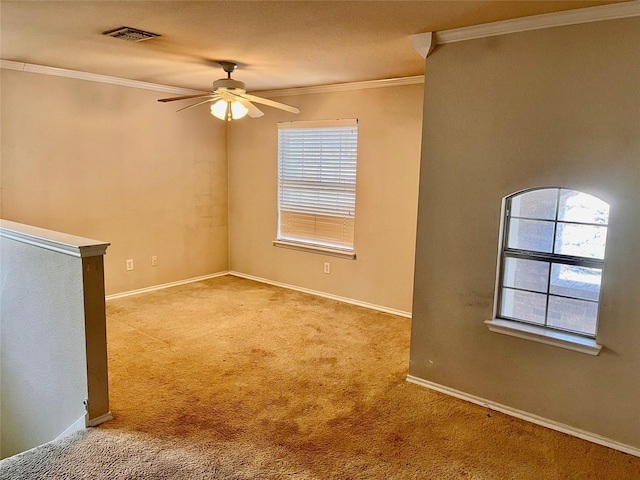 spare room with ceiling fan, crown molding, and light carpet