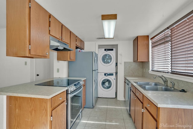 kitchen with backsplash, sink, light tile patterned flooring, stacked washer / dryer, and appliances with stainless steel finishes