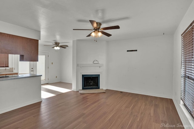 unfurnished living room featuring ceiling fan and hardwood / wood-style floors