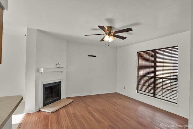 unfurnished living room with ceiling fan and wood-type flooring