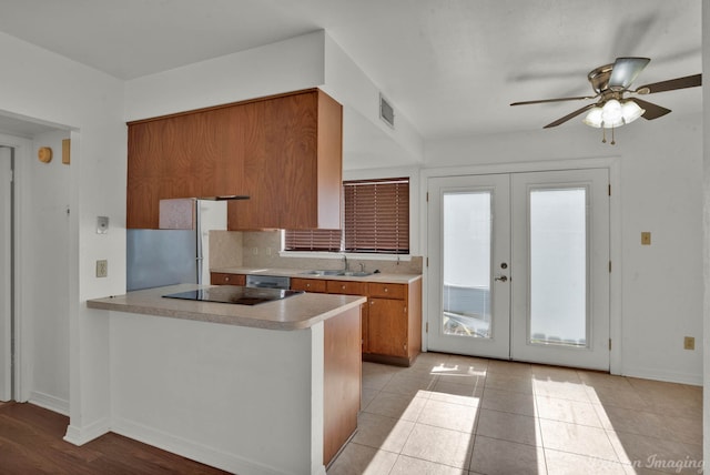 kitchen with black electric stovetop, french doors, sink, kitchen peninsula, and ceiling fan