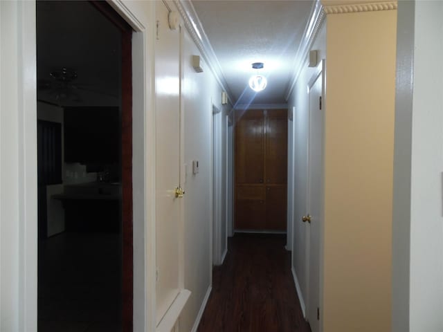 hallway featuring a textured ceiling, dark hardwood / wood-style floors, and ornamental molding