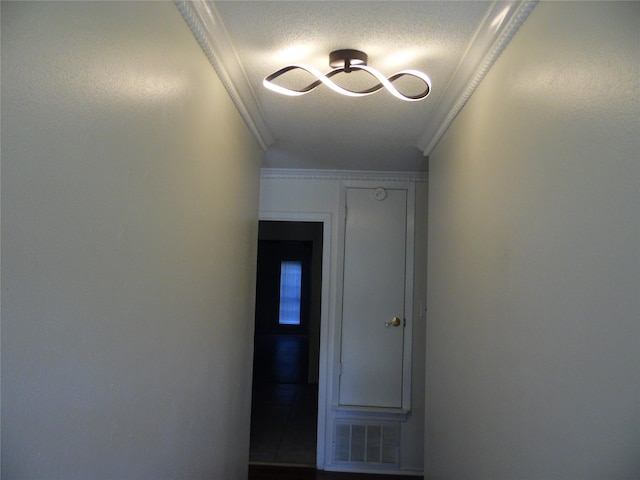 hallway with a textured ceiling and crown molding