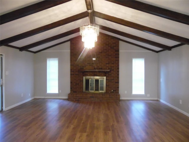 unfurnished living room featuring a brick fireplace, dark hardwood / wood-style flooring, a chandelier, and vaulted ceiling with beams