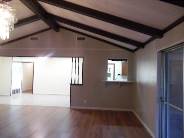 unfurnished living room featuring a notable chandelier, hardwood / wood-style flooring, and lofted ceiling with beams