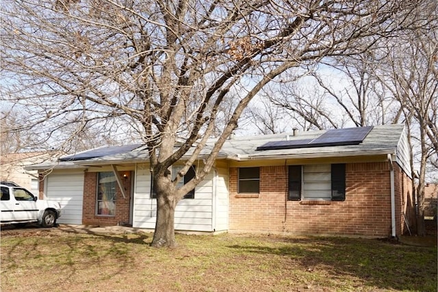 ranch-style house with a front yard and solar panels