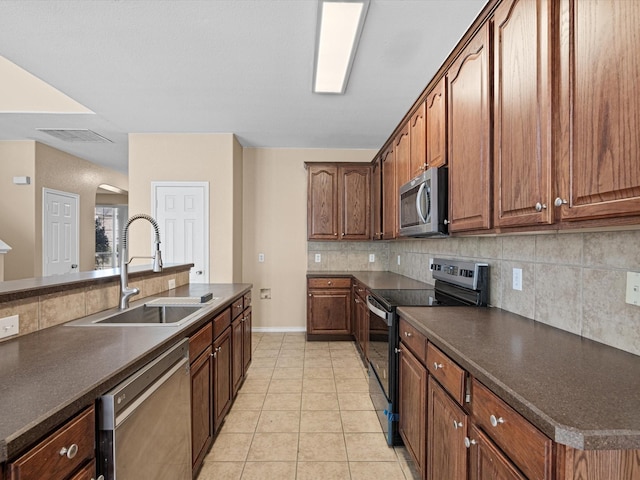 kitchen featuring decorative backsplash, sink, light tile patterned floors, and stainless steel appliances