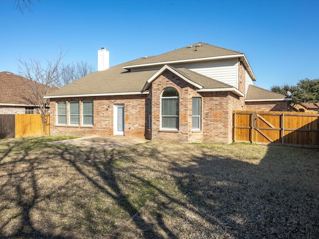 rear view of property with a lawn and a patio