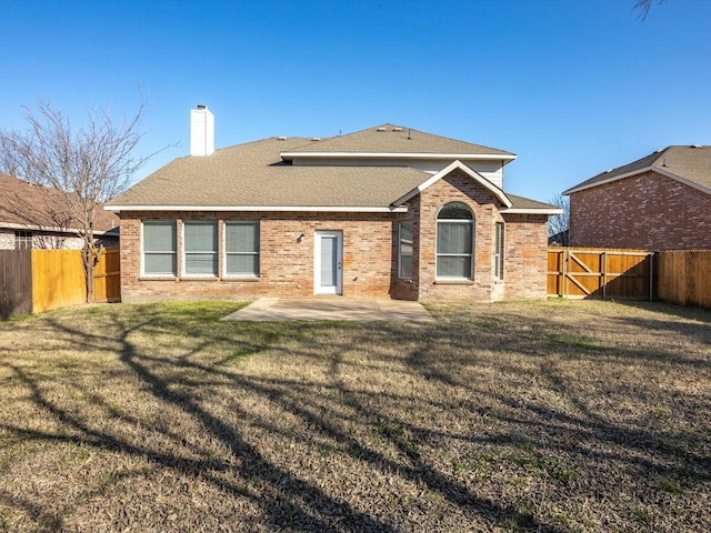 back of house featuring a patio area and a lawn