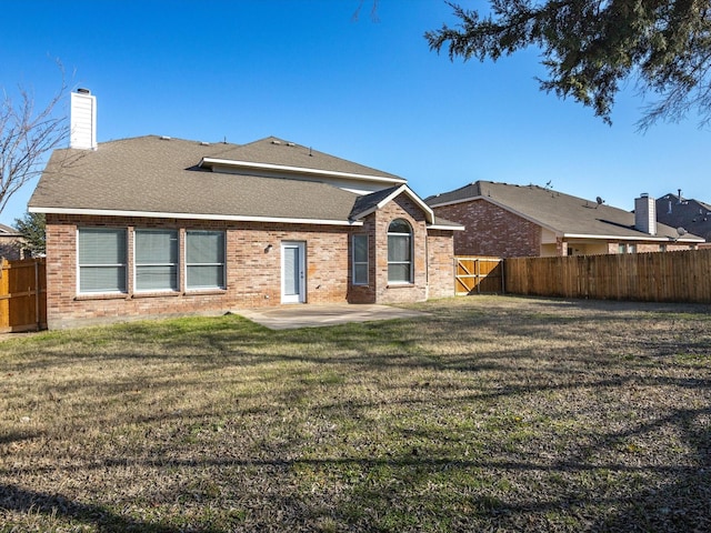 back of property featuring a lawn and a patio