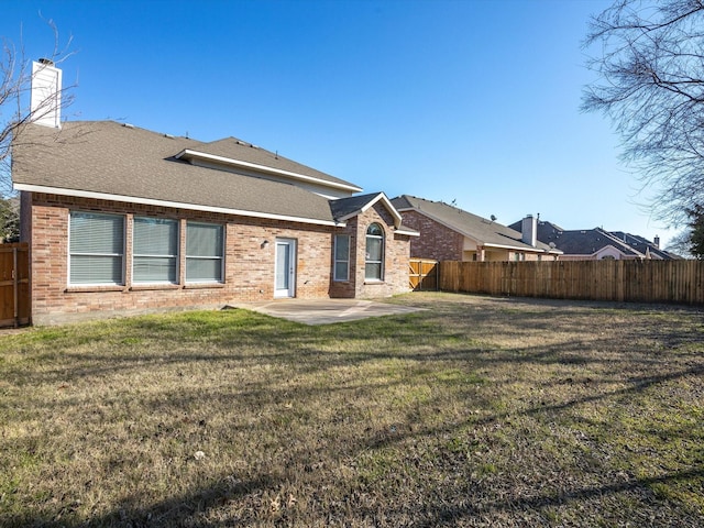 back of property featuring a yard and a patio