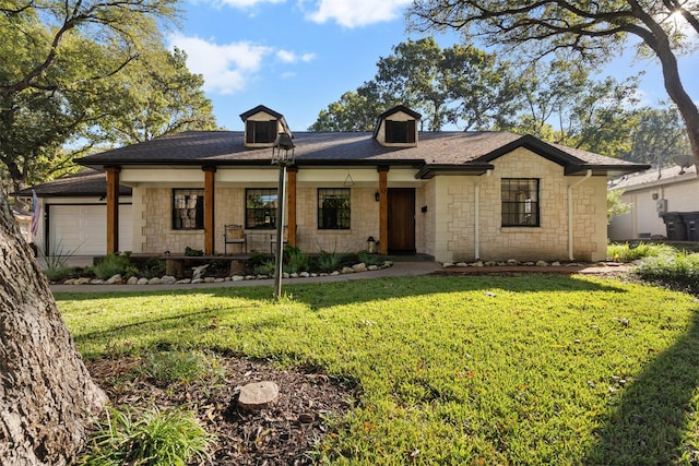 ranch-style home with a front yard, covered porch, and a garage