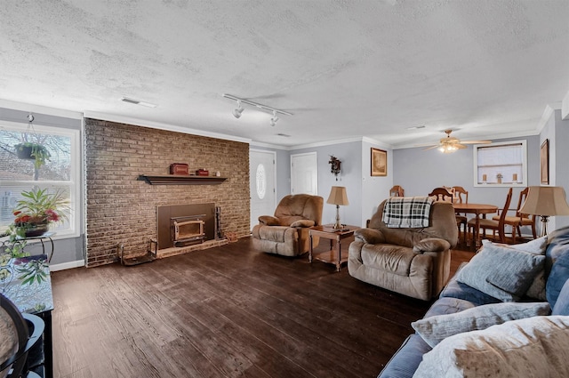 living room with ceiling fan, a textured ceiling, dark hardwood / wood-style floors, and ornamental molding