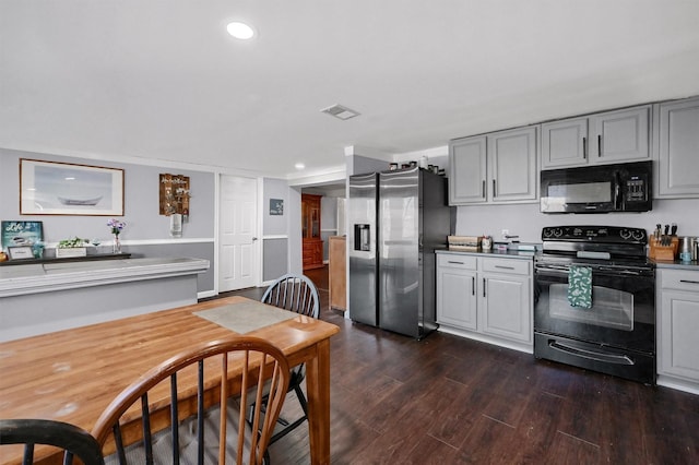 kitchen with gray cabinets, dark hardwood / wood-style floors, and black appliances