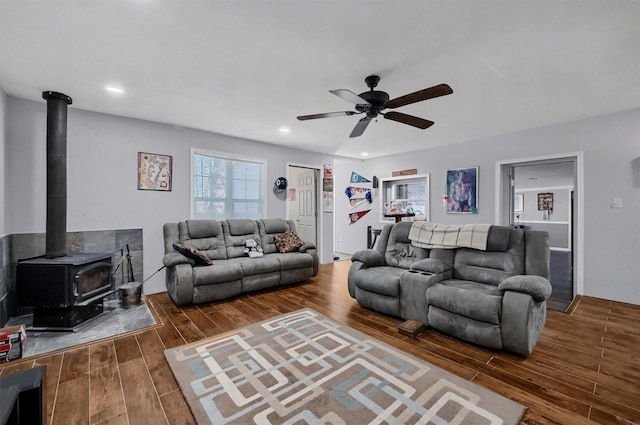 living room featuring ceiling fan and a wood stove