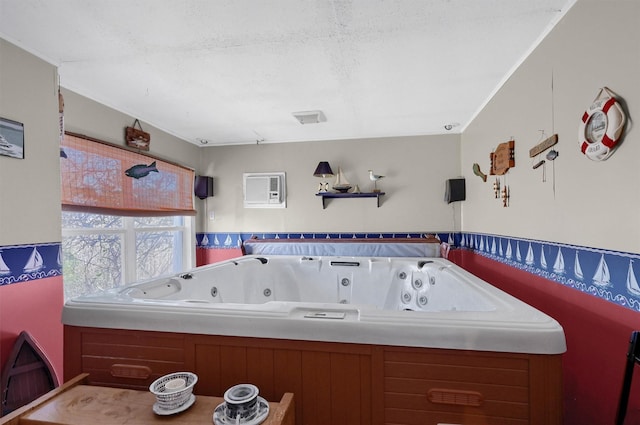 bathroom with a tub, a textured ceiling, and a wall unit AC