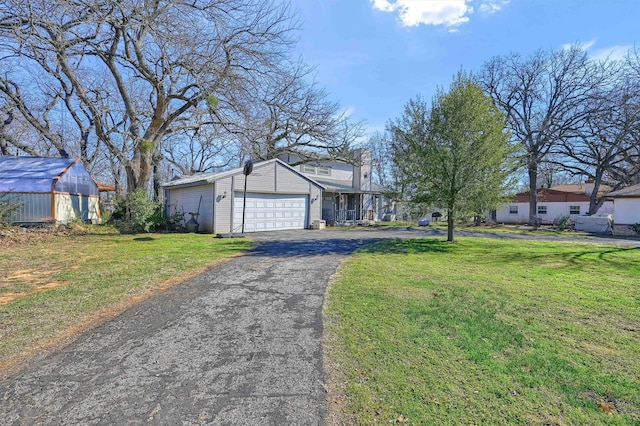 ranch-style house with a front yard, an outbuilding, and a garage