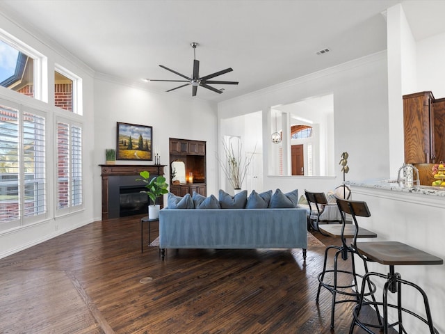 living room with ceiling fan, dark hardwood / wood-style flooring, and ornamental molding