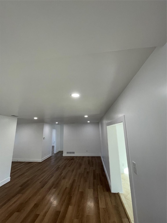 basement with dark hardwood / wood-style flooring