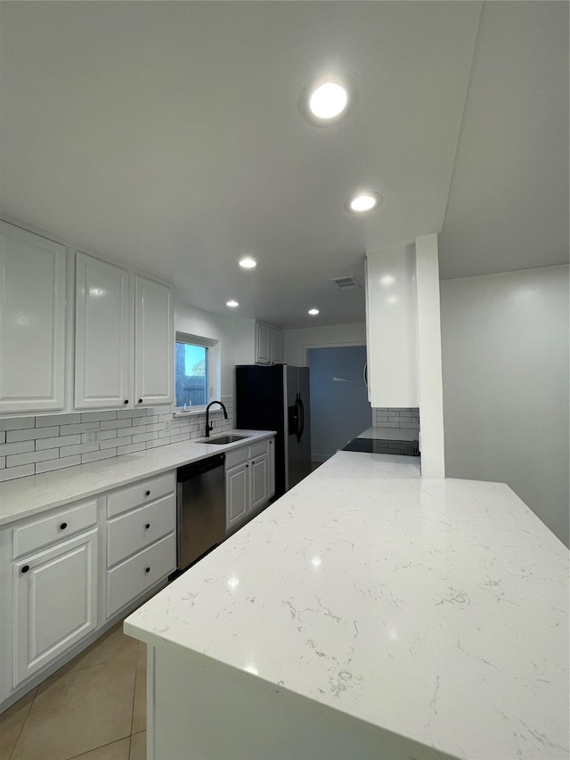 kitchen with white cabinetry, appliances with stainless steel finishes, backsplash, light stone countertops, and sink