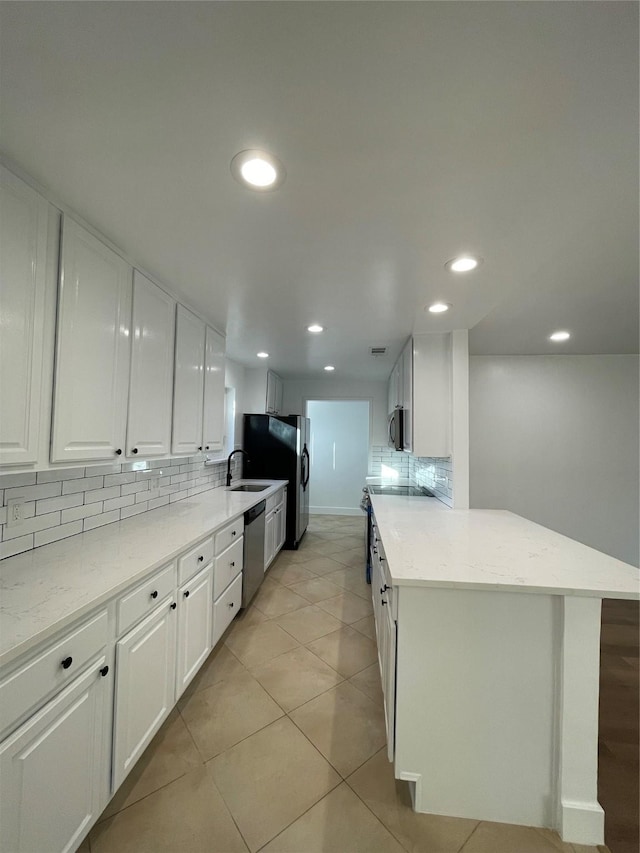 kitchen featuring appliances with stainless steel finishes, decorative backsplash, and white cabinets