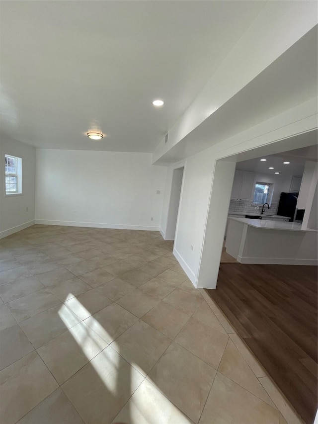 empty room featuring sink and light tile patterned flooring