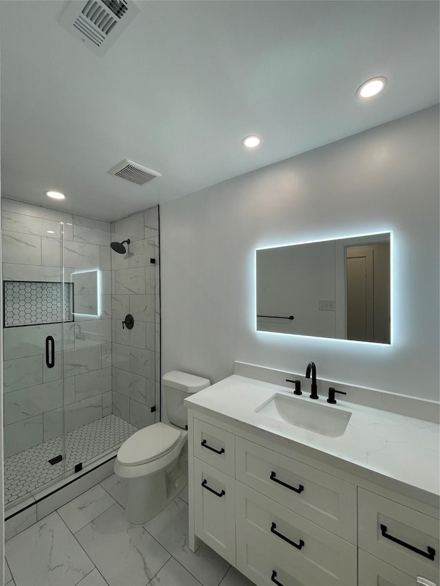 bathroom featuring toilet, vanity, and a shower with door