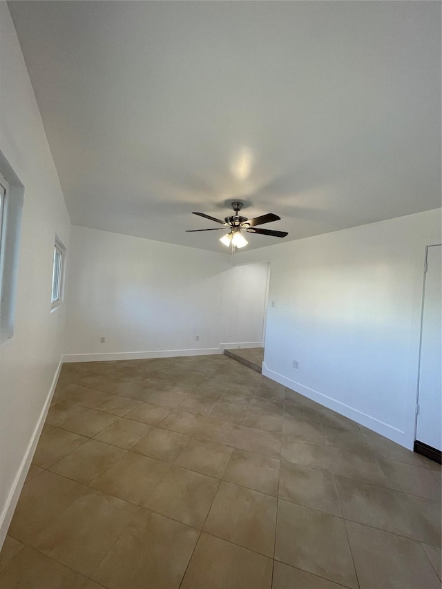 empty room with ceiling fan and light tile patterned floors