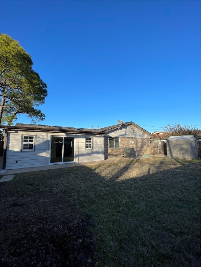 back of house with a lawn and central air condition unit