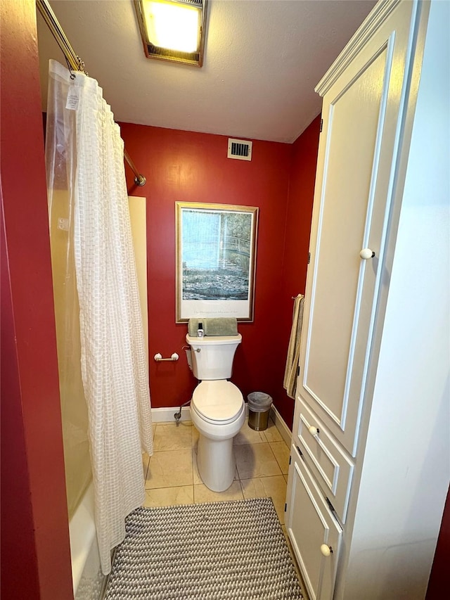 bathroom featuring toilet, tile patterned flooring, and shower / tub combo with curtain