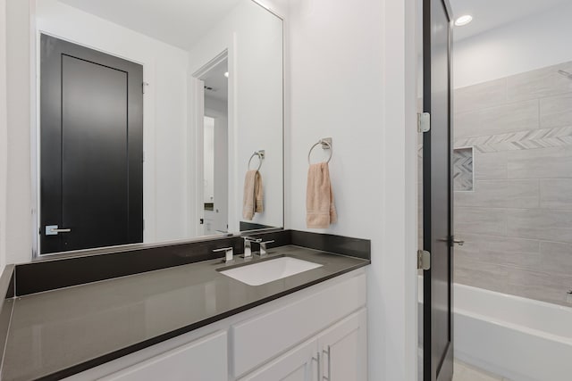 bathroom featuring washtub / shower combination and vanity