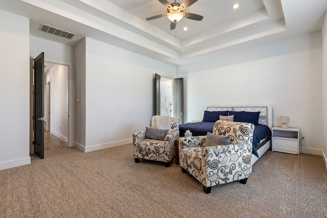 carpeted bedroom with visible vents, a ceiling fan, a raised ceiling, and baseboards