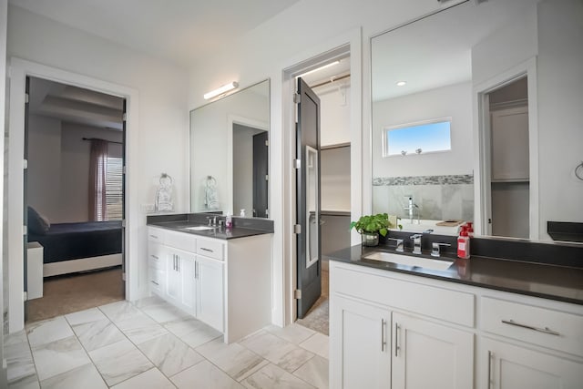 bathroom featuring two vanities, marble finish floor, and a sink