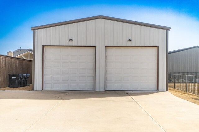 detached garage featuring fence