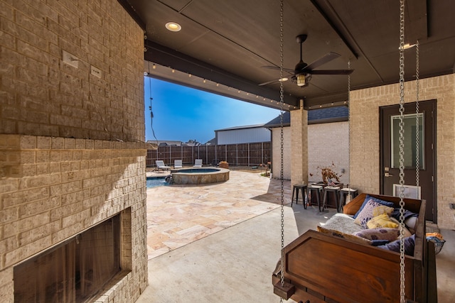 view of patio / terrace featuring a fenced backyard, an outdoor brick fireplace, a pool with connected hot tub, and ceiling fan