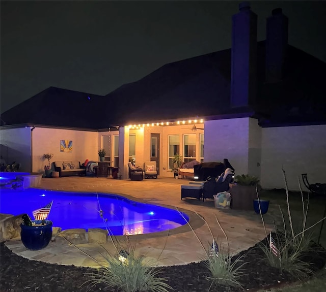 pool at twilight featuring an outdoor living space, an outdoor pool, and a patio area