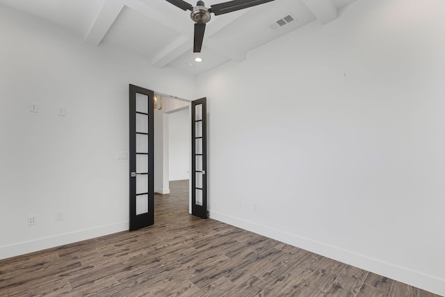 empty room with baseboards, beam ceiling, visible vents, and wood finished floors