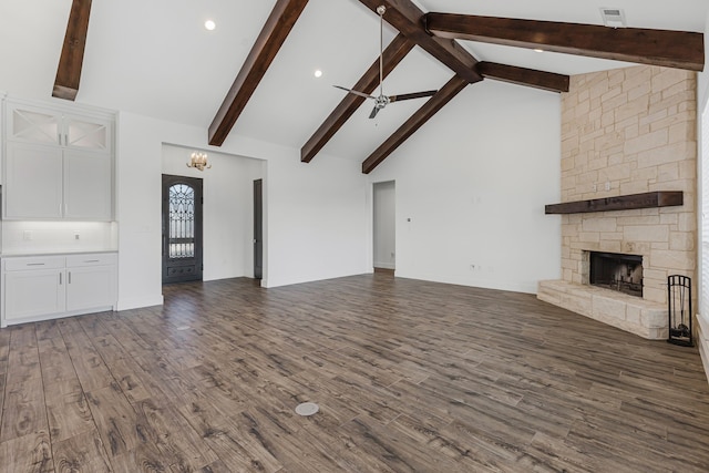 unfurnished living room with a ceiling fan, wood finished floors, high vaulted ceiling, a fireplace, and beamed ceiling