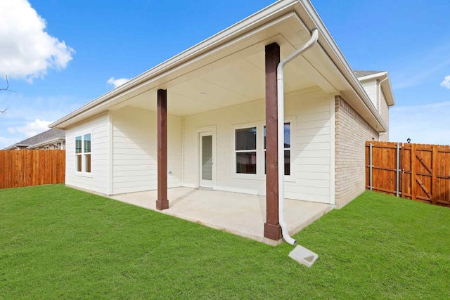 rear view of house with a lawn and a patio