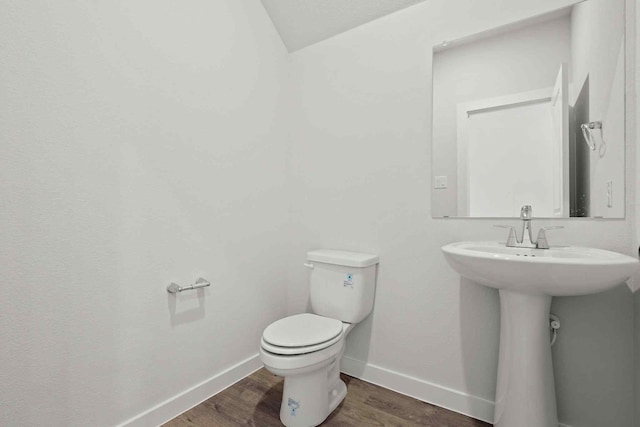 bathroom featuring wood-type flooring and toilet