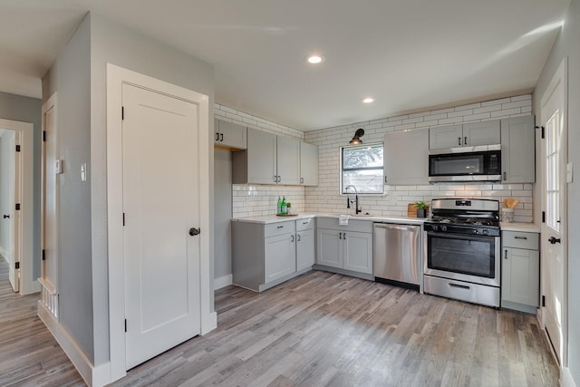 kitchen featuring backsplash, appliances with stainless steel finishes, and gray cabinetry